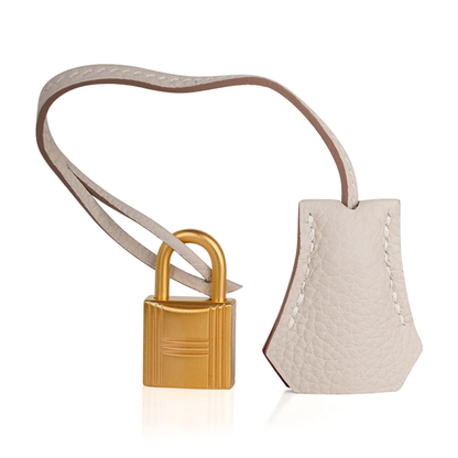 Soft Pale Concrete Neutral Gentle Pebbled Grain Compact Structured Hand Tote With Vibrant Pink Inner Lining, Brushed Golden Twist Lock Hardware And Matching Neutral Suspended Metal Padlock Charm